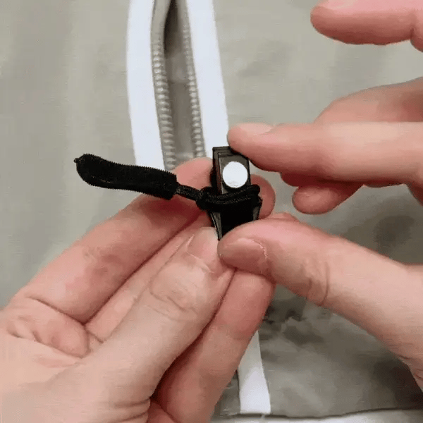 Seller demonstration of a replacement slider being fitted to a jacket zipper